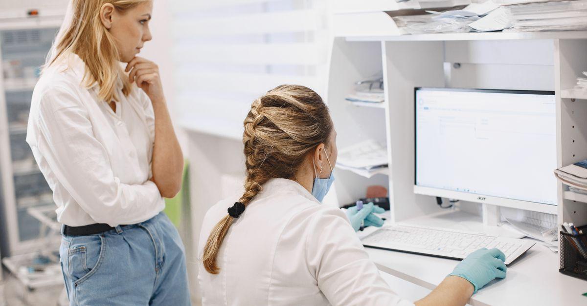 Dos profesionales de una clínica revisando datos de pacientes en un ordenador