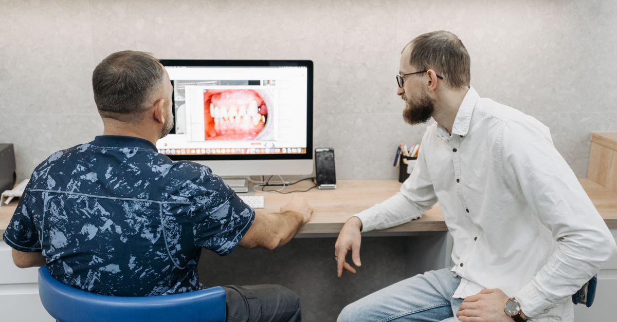 Dos profesionales de una clínica dental revisando juntos información en una pantalla