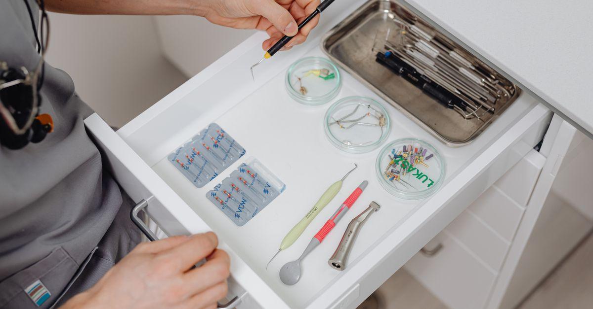 Profesional dental organizando instrumental en un cajón de la clínica