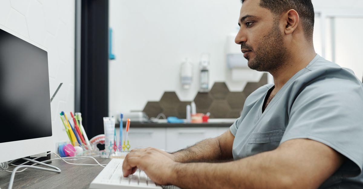 Profesional de una clínica dental consultando información en el ordenador